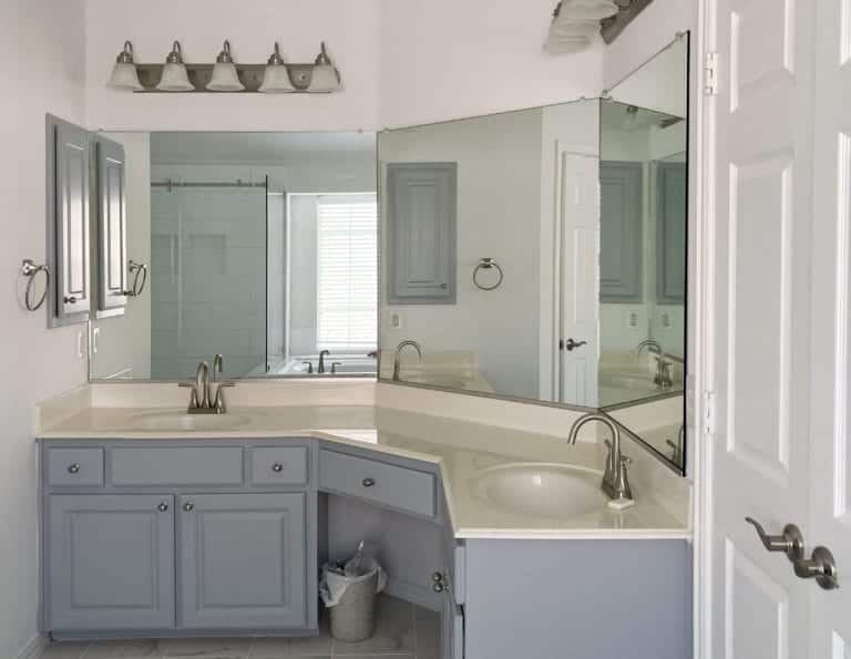 A bathroom with two sinks and a mirror.