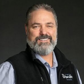 A man with a beard smiling for the camera.