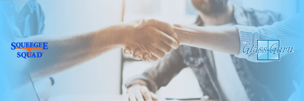 Two people forming a referral partnership while shaking hands in front of a blue background.