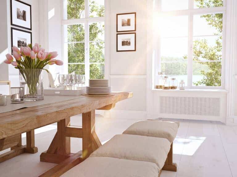 A white dining room with a wooden table and chairs featuring replacement windows.